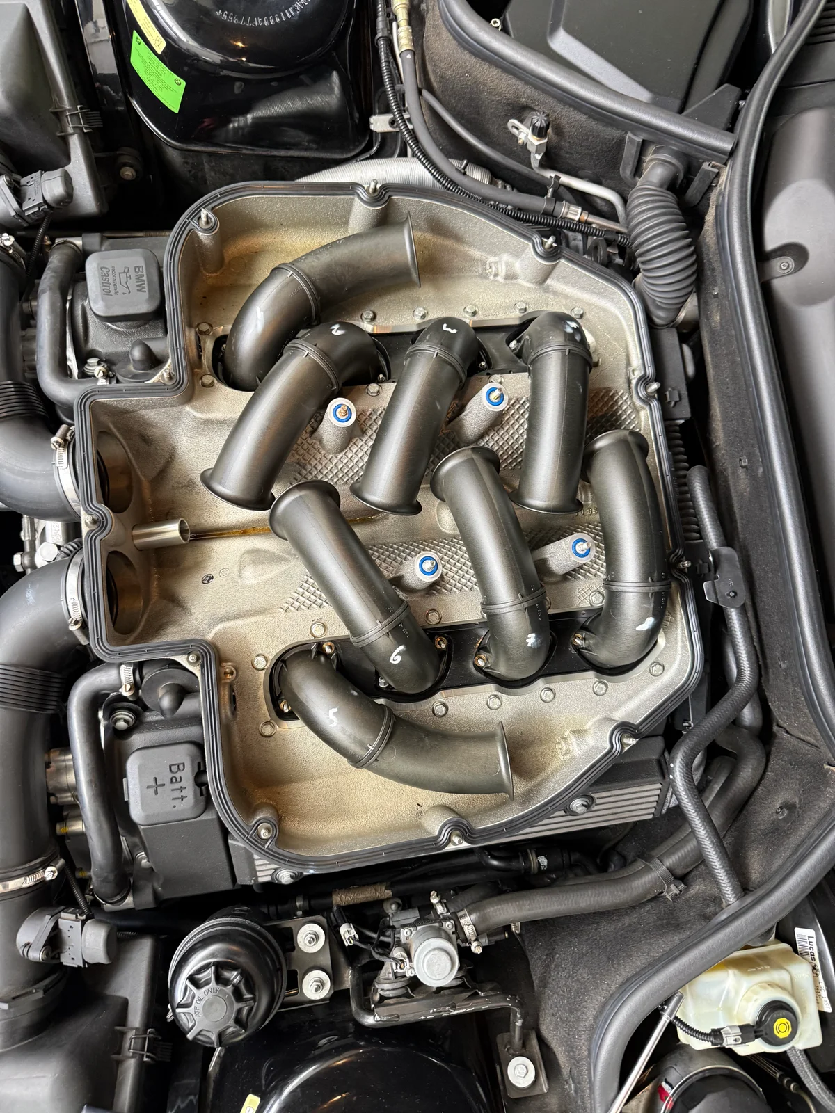 Blick in den geöffneten Motorraum eines BMW in der Werkstatt